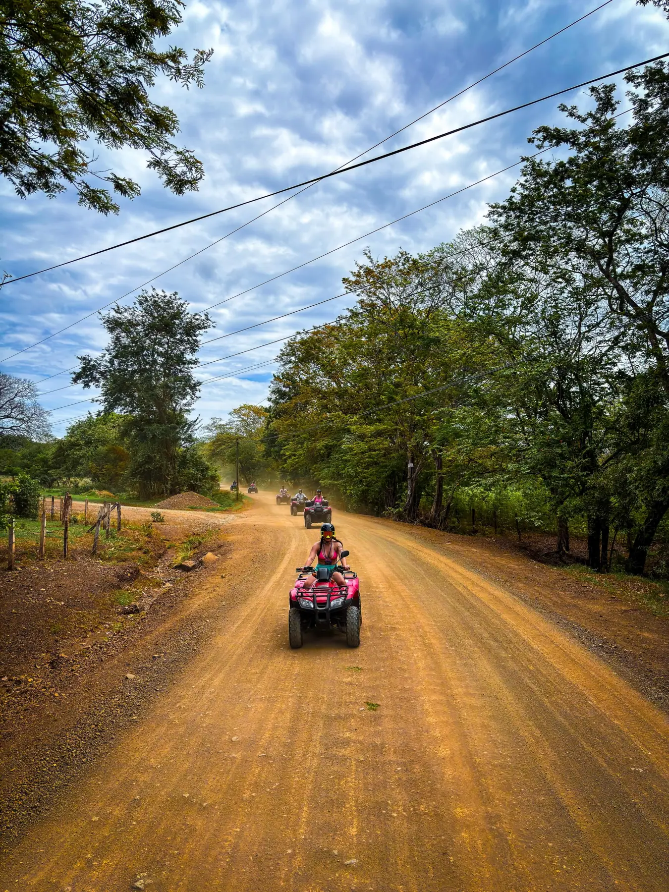 ATV convoy riding the orange dirt roads of Guanacaste